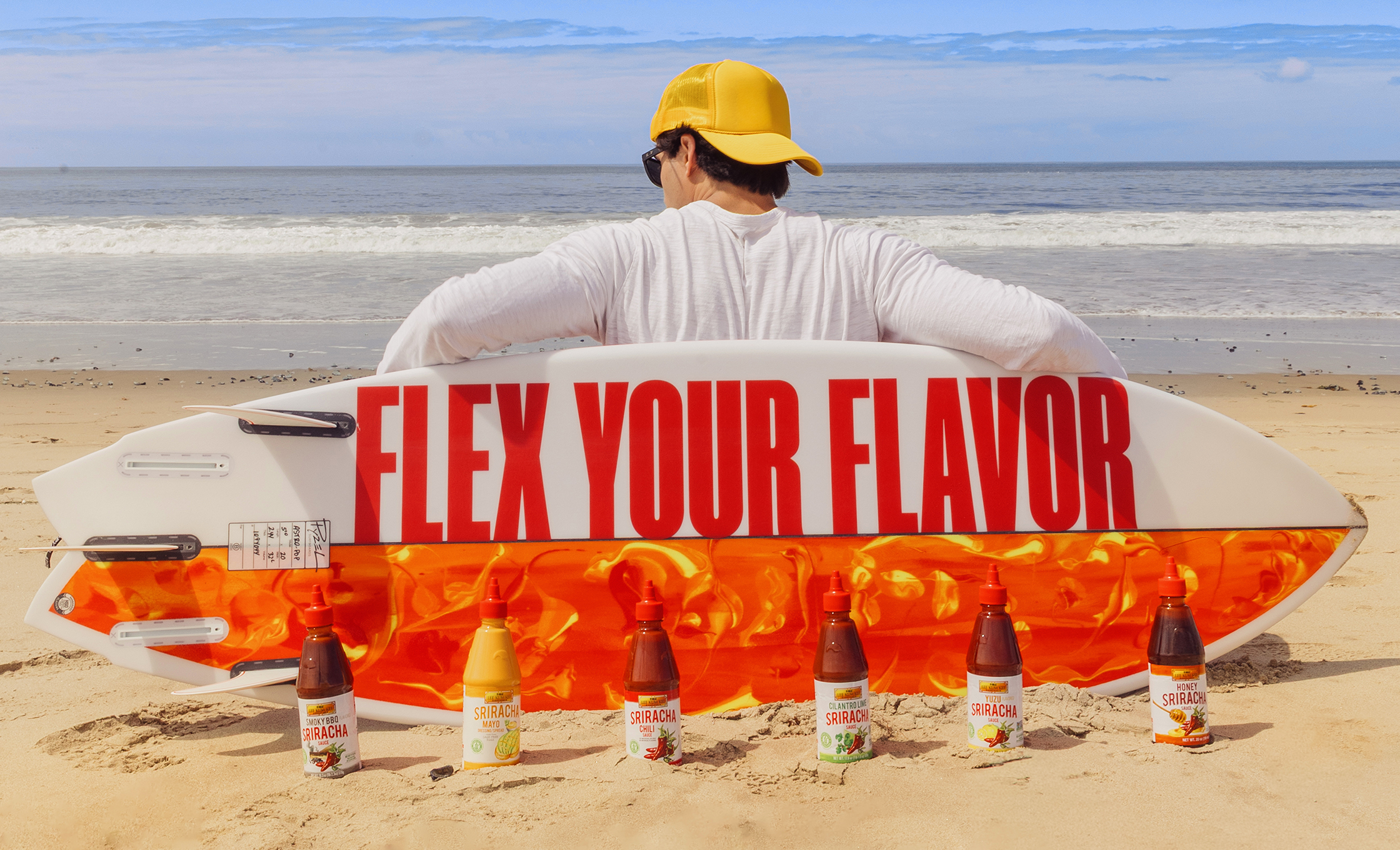 Man leaning on custom surfboard that says, 